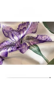 Détail d'un foulard en soie montrant la couture fine et l'imprimé floral d'iris violet