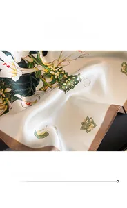 Detailed view of silk square scarf featuring lily floral print and fine rolled edges