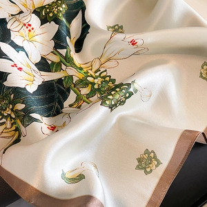 Floral print mulberry silk square scarf with hand-rolled edges on leather background