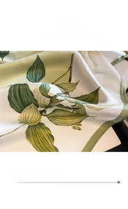 Détail d'un foulard en soie à fleurs montrant la couture fine et la texture lisse