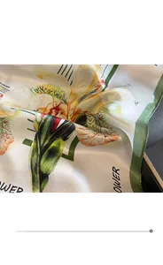 Macro detail of floral silk scarf featuring neat machine-stitched edges and smooth texture