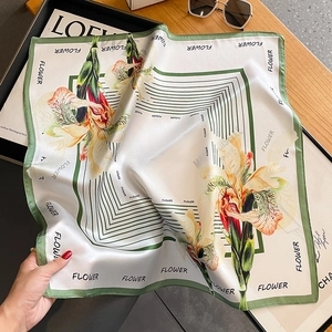 Elegant silk square scarf with iris floral print and green border in a stylish setting