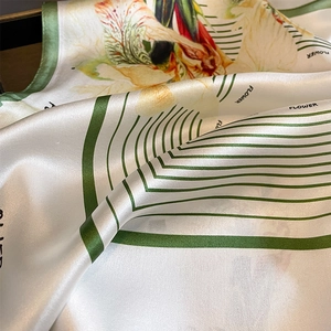 Elegant floral silk square scarf with geometric green patterns and smooth silk texture