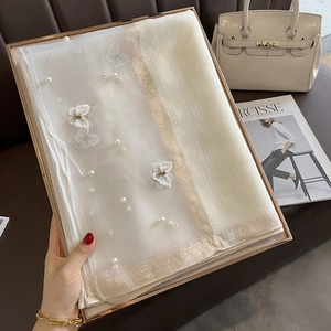 Détail d'une écharpe en maille blanche avec broderie papillon et perles en boîte cadeau