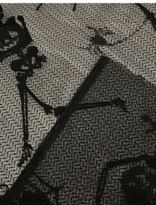 Macro shot of Halloween black lace fabric with intricate skull and skeleton patterns