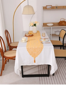 Detailed yellow hollow lace table runner with intricate floral patterns and elegant tassels