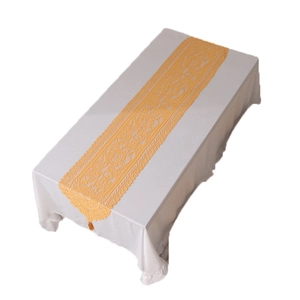 Yellow hollow out lace table runner with fringe tassel on white tablecloth