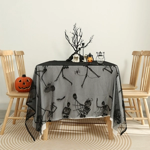 Halloween black lace tablecloth with skeletons and spiders on a wooden dining table