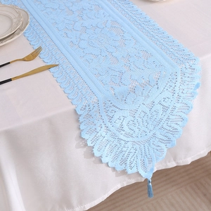 Light blue hollow floral lace table runner with tassels for a vintage dining table