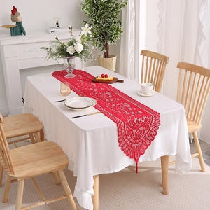 Red lace table runner with hollow floral pattern and elegant decorative tassels