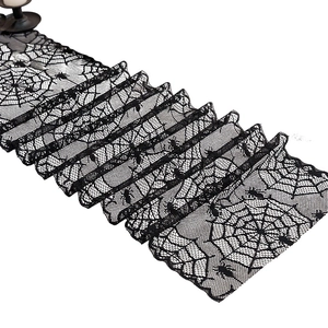 Halloween black lace table runner featuring intricate spider web patterns on white background