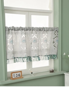 Detail showing elegant floral embroidery and green ruffled edge on the lace cafe curtain