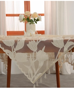 Detail of tulip lace tablecloth with elegant tassels and crochet floral texture
