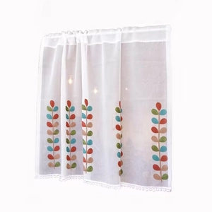 Tenda da cucina semitrasparente con foglie colorate e nappe a pompon sul bordo basso