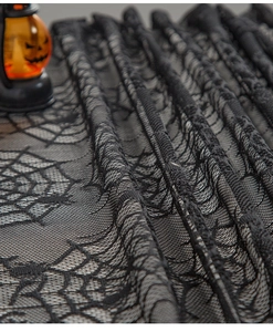 Detail of black lace spiderweb table runner with mesh texture for Halloween decor