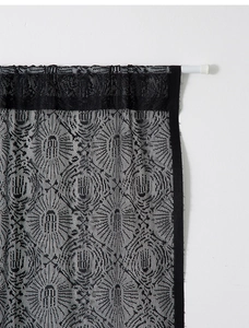 Close-up of black lace Halloween curtain showing intricate spider web and hand motifs