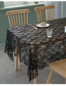 Detail of elegant black lace tablecloth with vintage rose pattern and scalloped edges