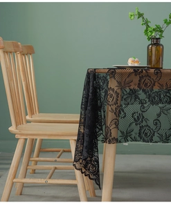 Close-up of black lace table runner with intricate floral patterns on a wooden table