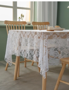 Detailed view of white floral lace tablecloth featuring delicate hollow mesh patterns