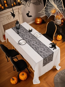Detail of black lace Halloween table runner featuring an intricate spider web texture