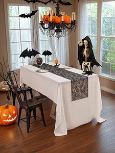 Close-up van Halloween tafelloper met zwart spinnenwebkant over wit tafelkleed