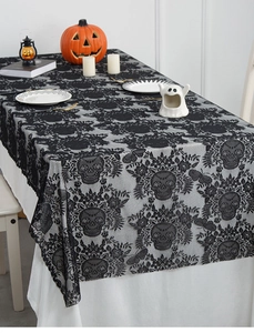 Detail of black lace Halloween tablecloth featuring intricate skull and floral pattern