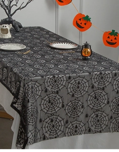 Detail of black lace Halloween tablecloth with intricate spider web and spider patterns