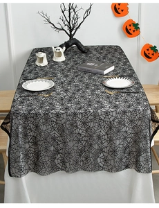 Detailed view of Halloween black lace spider web tablecloth styled with festive pumpkins