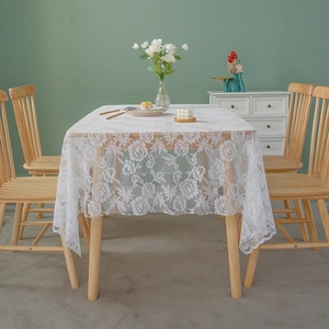 Elegant white lace tablecloth with floral patterns on a wooden table for home decor