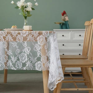 Elegant white lace tablecloth with floral hollow patterns and scalloped edges for home decor