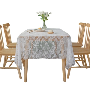 Elegant white lace tablecloth featuring intricate rose floral patterns on a dining table
