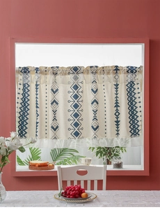 Detail of bohemian cafe curtain with blue geometric patterns and delicate wavy frill edges