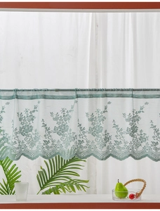 Detail of light green floral lace cafe curtain with elegant wavy edge and rod pocket