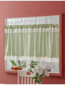Close-up of green and white plaid cafe curtain featuring white ruffled edges and rod pocket