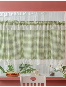 Detailed view of green checkered cafe curtain with white lace ruffles in a kitchen setting