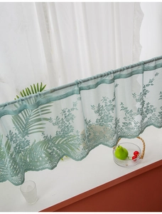 Detailed close-up of grey-green lace cafe curtain with delicate floral embroidery