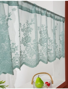 Detail of light green lace cafe curtain with vintage floral patterns and wavy hem