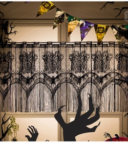 Detail of Halloween black lace curtain featuring skull and bat patterns with fringe