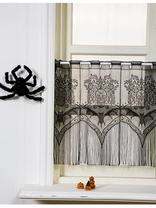 Detail view of Halloween black lace curtain with skull patterns and long fringe tassels