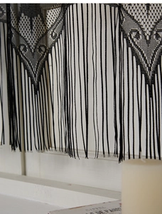 Detail of black lace tassel runner with vintage geometric patterns for Halloween decor