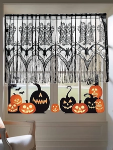 Detail of Halloween black lace curtain with skull patterns and hanging fringe trim