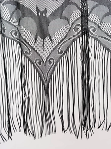 Close-up of black lace Halloween decor featuring hollowed-out bat patterns and long tassels