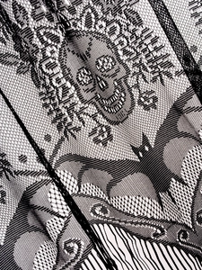 Macro detail of black lace fabric featuring skull and bat patterns for Halloween decor