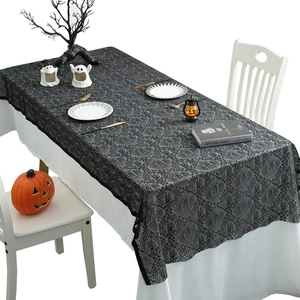Black lace Halloween tablecloth with cobweb pattern on a decorated holiday table