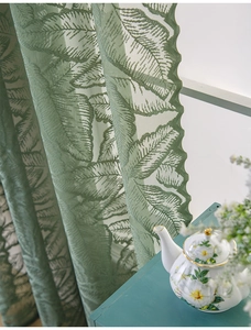 Dettaglio del motivo jacquard a felce verde su tende in pizzo con bordi ondulati