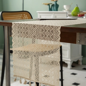 Beige hollow knit table runner with geometric lace pattern and handmade tassels