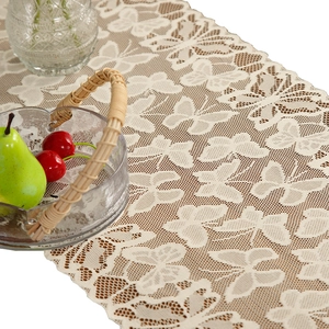 Elegant cream lace table runner with hollow butterfly pattern on a rustic wooden table