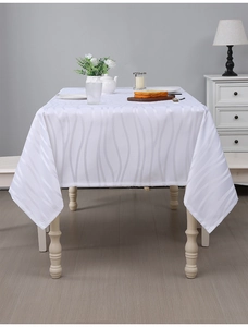 Macro shot of white jacquard tablecloth showing wavy texture and premium silk-like fabric