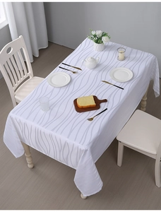 Close-up of white American style tablecloth with vertical jacquard and light grey wavy lines