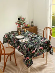Detail of chenille tablecloth featuring flamingo and palm leaf patterns on black background